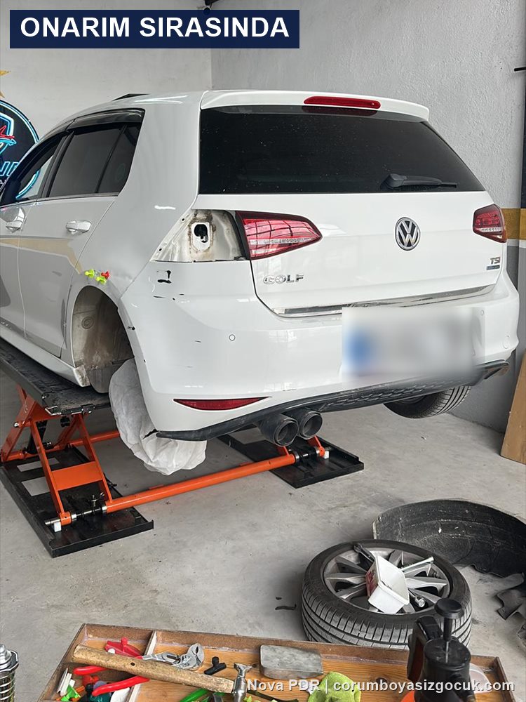 Volkswagen Golf arka çamurluk göçük onarımı sırasında liftte, teker ve stop lambası sökülmüş